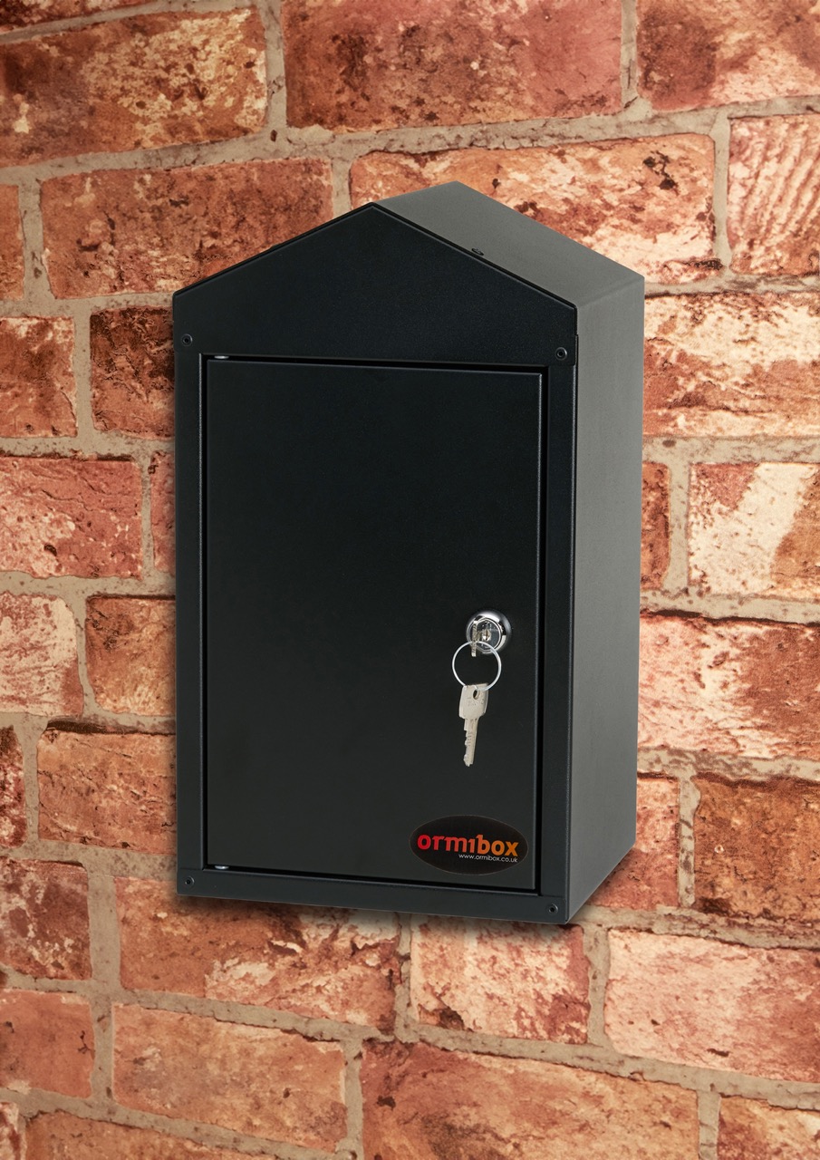 Black-Tap-Box-Attached-To-A-Brick-Wall-To-Protect-Your-Outdoor-Tap-The-Tap-Box-Has-A-Camlock-Locking-System-And-A-Triangluar-Sloped-Roof-To-Prevent-Water-Pooling